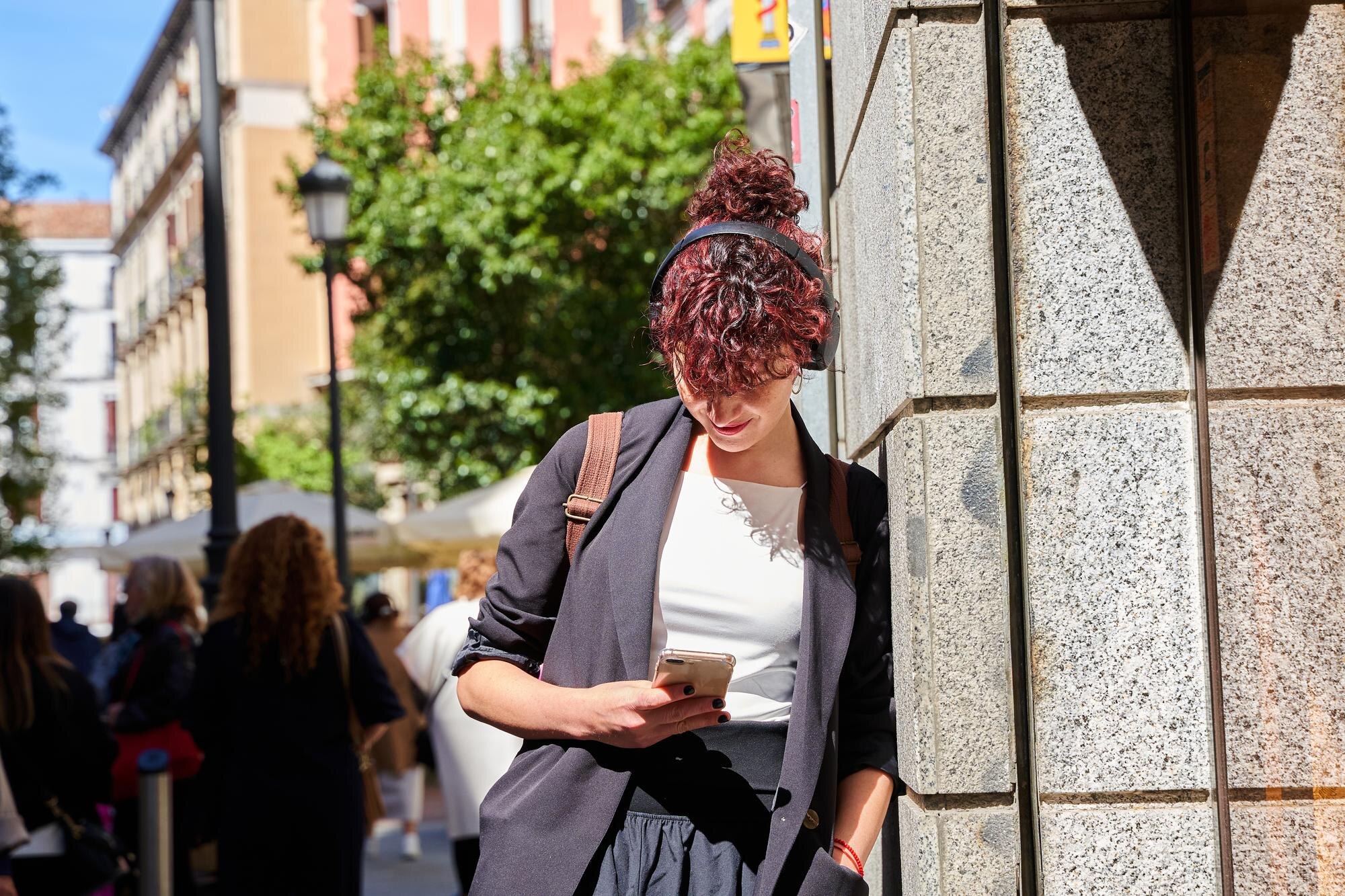 curlyhaired woman texting mobile phone madrid street 672594 3235
